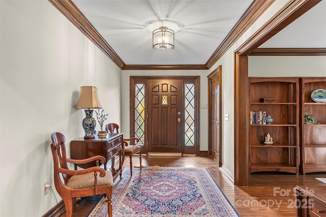 foyer featuring ornamental molding, wood finished floors, and baseboards