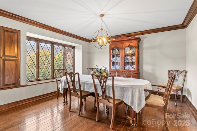 dining space featuring ornamental molding, wood-type flooring, and baseboards