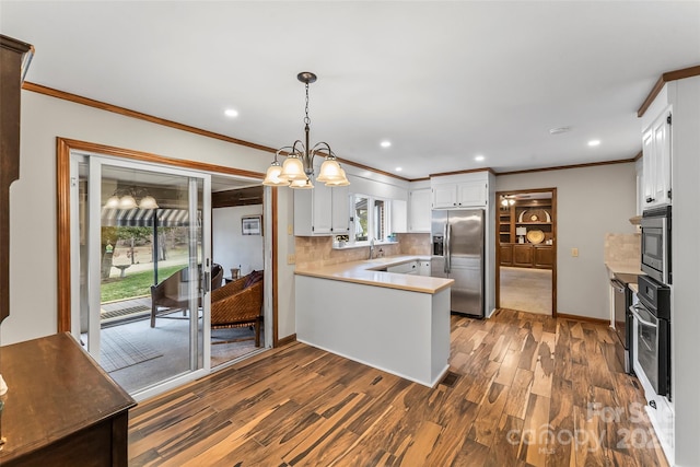 kitchen featuring a peninsula, dark wood-type flooring, white cabinetry, light countertops, and appliances with stainless steel finishes