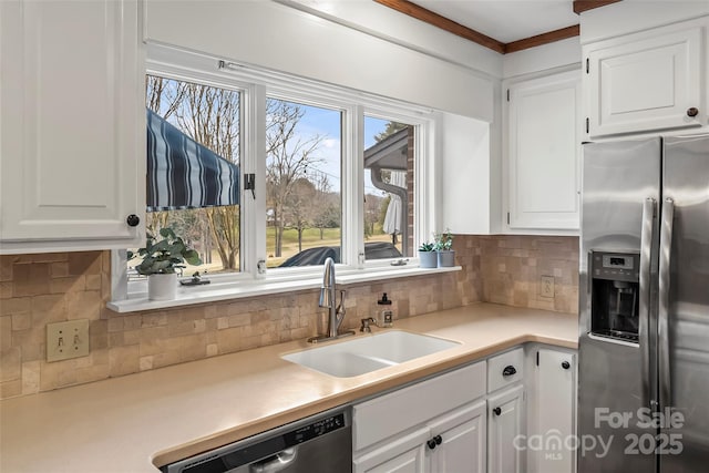 kitchen with decorative backsplash, appliances with stainless steel finishes, light countertops, white cabinetry, and a sink