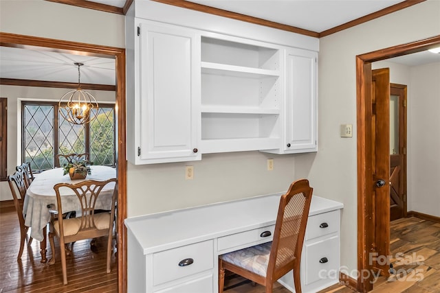 home office with a chandelier, built in study area, crown molding, and wood finished floors