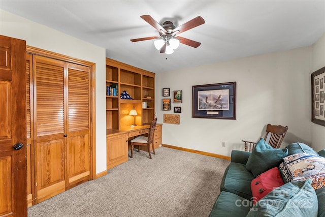 office with baseboards, ceiling fan, built in study area, and light colored carpet