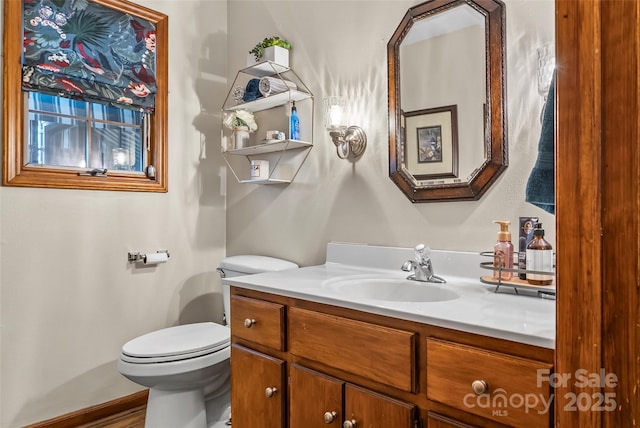 bathroom with vanity, toilet, and baseboards