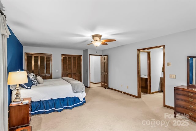 bedroom featuring ceiling fan, two closets, light colored carpet, and baseboards