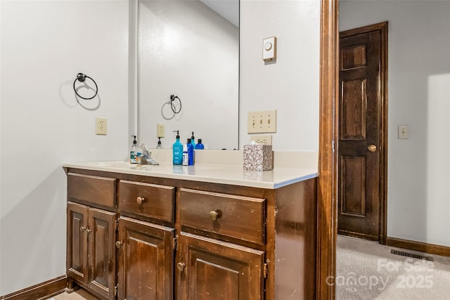 bathroom with baseboards, visible vents, and vanity