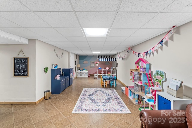 game room featuring a paneled ceiling, tile patterned flooring, and baseboards