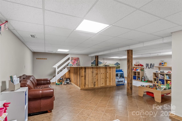 rec room with a bar, a drop ceiling, and visible vents