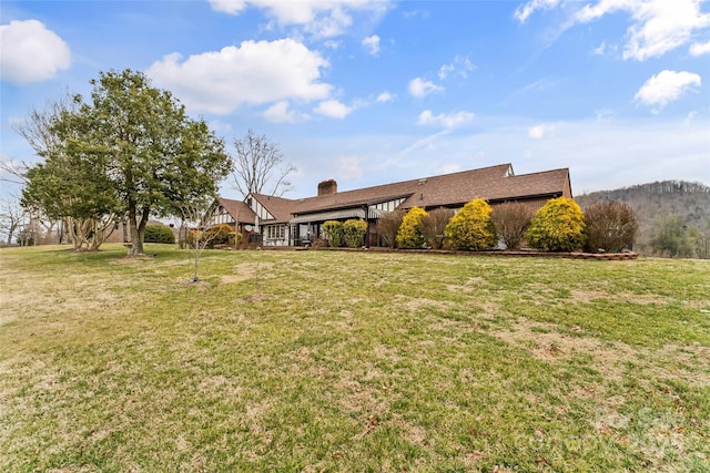 view of front of house with a front yard and a chimney