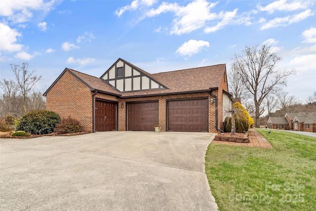 tudor home with an attached garage, brick siding, a shingled roof, concrete driveway, and a front lawn