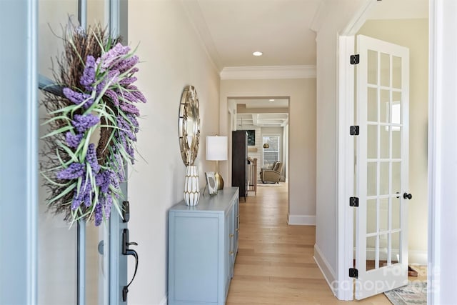 hallway with light wood-style floors, ornamental molding, baseboards, and recessed lighting