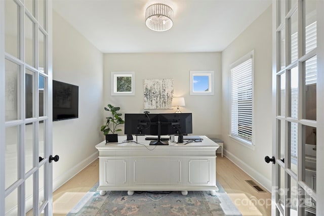 home office with baseboards, visible vents, french doors, and light wood-style flooring