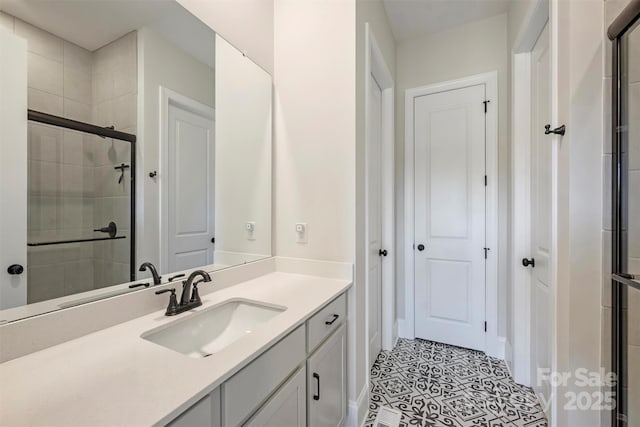 bathroom with vanity, baseboards, and tiled shower