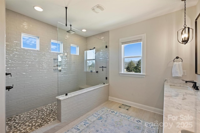 bathroom featuring walk in shower, wood finished floors, vanity, baseboards, and recessed lighting