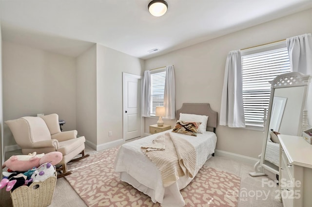 bedroom featuring baseboards, visible vents, and light carpet