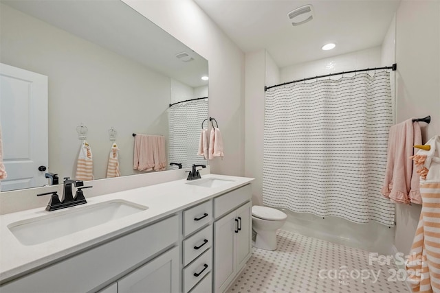 full bathroom with double vanity, toilet, a sink, and shower / bath combo