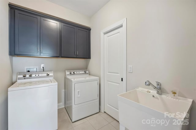 clothes washing area with washing machine and clothes dryer, light tile patterned floors, a sink, and cabinet space