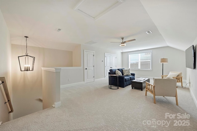 living area with vaulted ceiling, visible vents, light colored carpet, and an upstairs landing