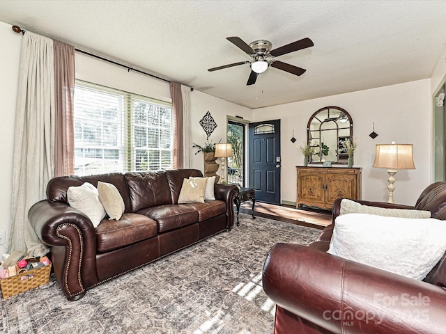 living room with a textured ceiling and ceiling fan