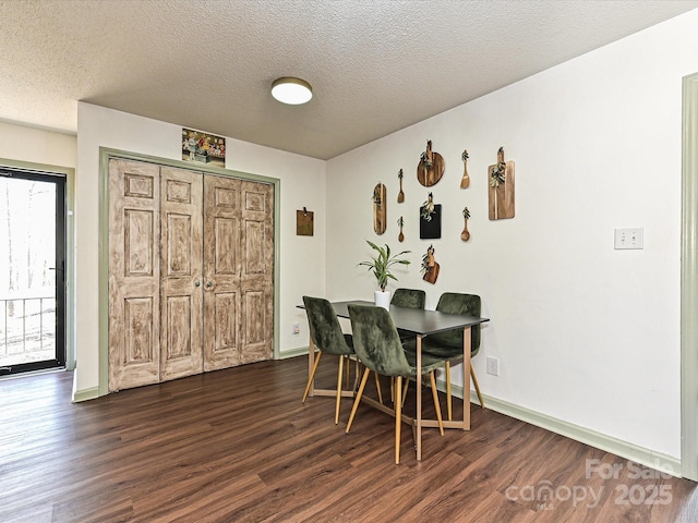 dining area featuring baseboards, dark wood-type flooring, and a textured ceiling