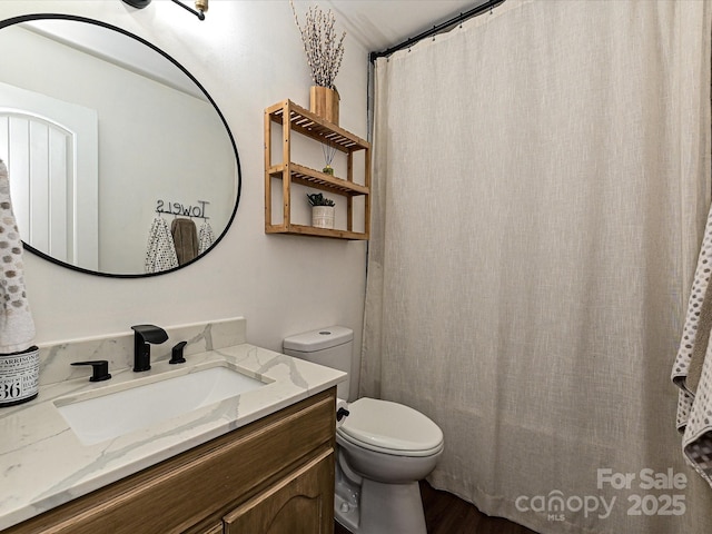 bathroom with vanity, curtained shower, and toilet