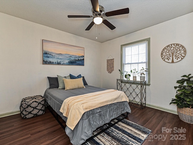 bedroom with a ceiling fan, wood finished floors, baseboards, and a textured ceiling