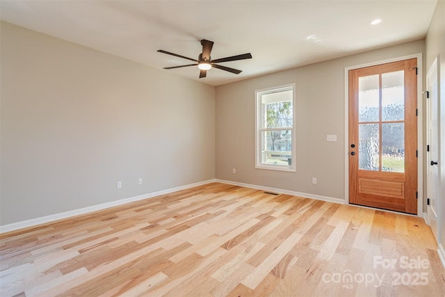 interior space featuring light wood-type flooring, baseboards, visible vents, and ceiling fan