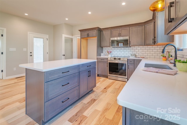 kitchen with a sink, appliances with stainless steel finishes, and light countertops