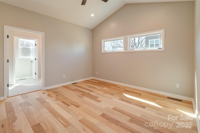 unfurnished room with a wealth of natural light, visible vents, and light wood finished floors