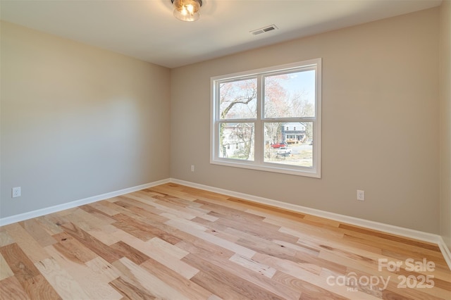 spare room with light wood-style flooring, baseboards, and visible vents