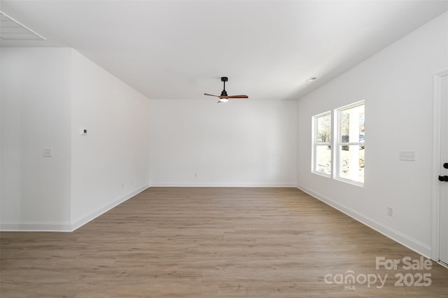 empty room with baseboards, ceiling fan, and light wood finished floors