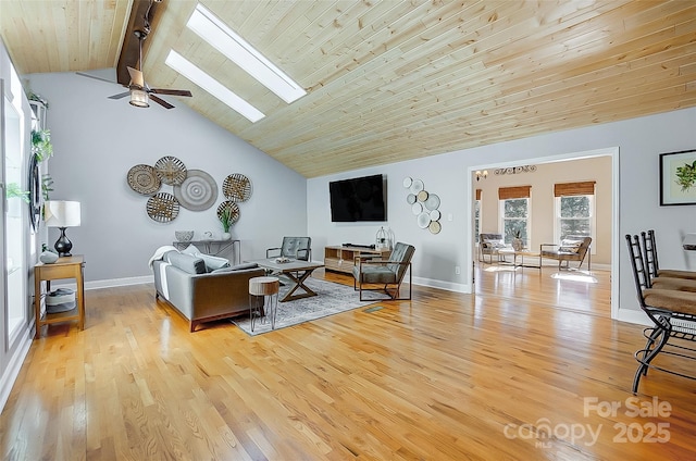 living area featuring baseboards, a skylight, and light wood-style floors