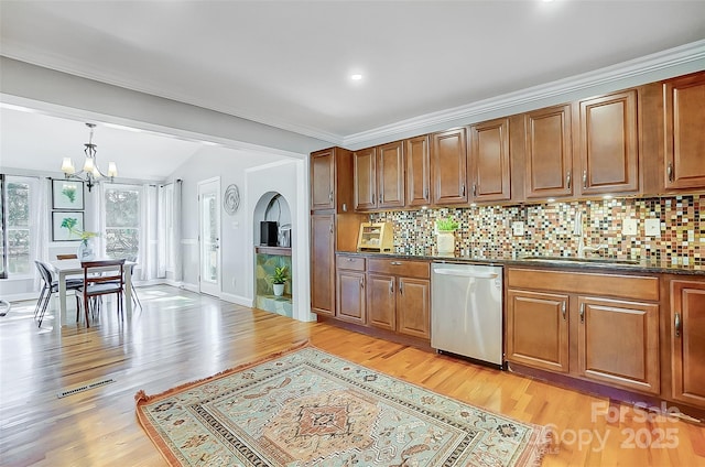 kitchen with dark countertops, visible vents, light wood-style floors, a sink, and dishwasher