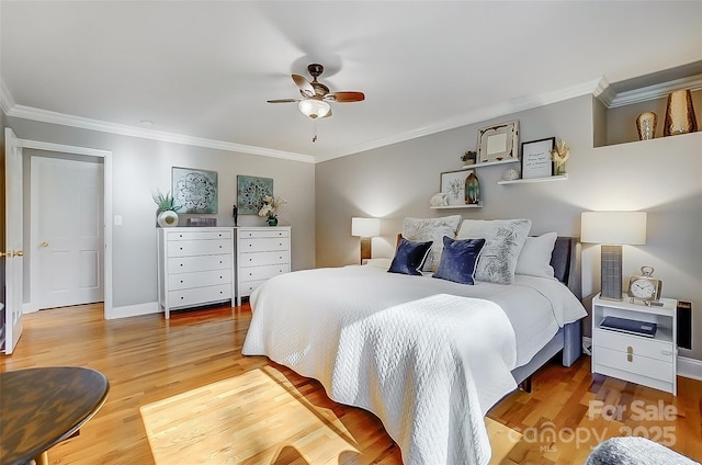 bedroom with ornamental molding, baseboards, and wood finished floors