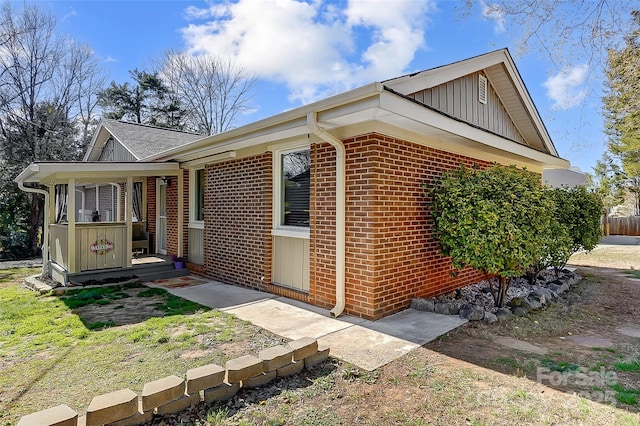 exterior space featuring brick siding, board and batten siding, and a porch