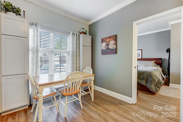 dining room with baseboards, light wood-style flooring, and crown molding