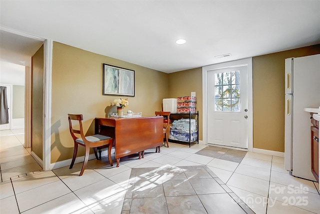 entryway with light tile patterned floors, baseboards, and visible vents