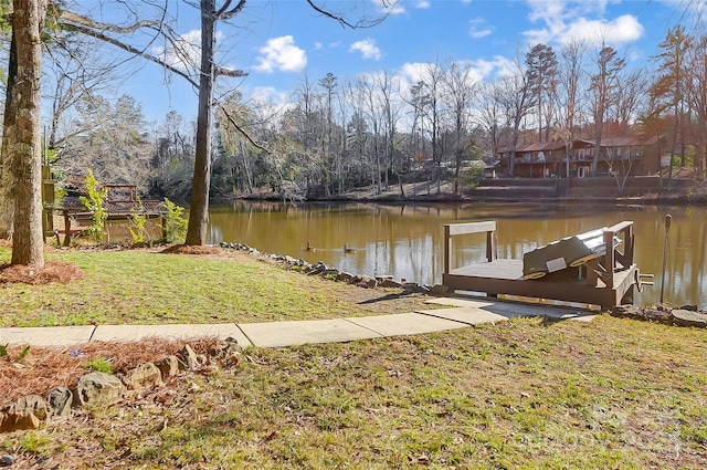 dock area with a water view and a yard