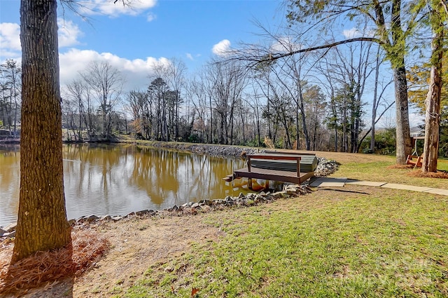 view of dock with a water view and a yard