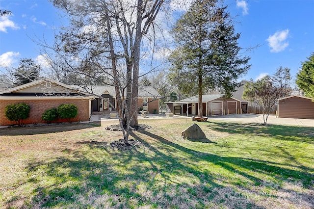 view of yard featuring a detached garage and an outdoor structure