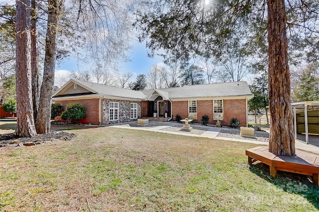 back of property with a yard, fence, and brick siding