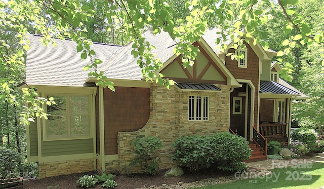 39 Hawks Pointe Ln, Weaverville, NC 28787 - tudor home featuring stone siding, a shingled roof, a standing seam roof, and a metal roof