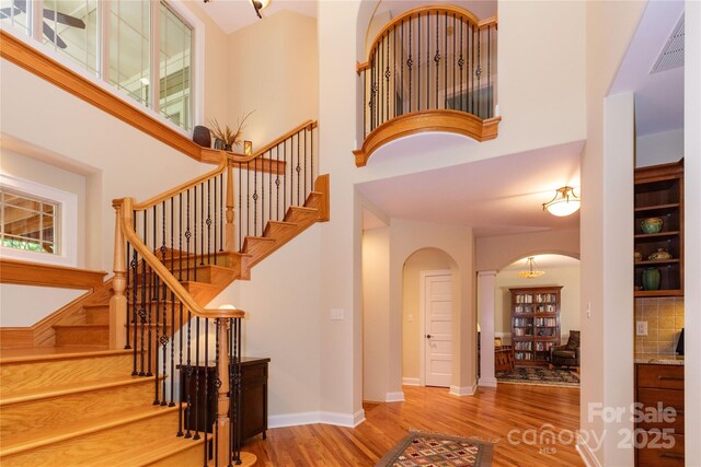 39 Hawks Pointe Ln, Weaverville, NC 28787 - staircase with arched walkways, wood finished floors, and a high ceiling