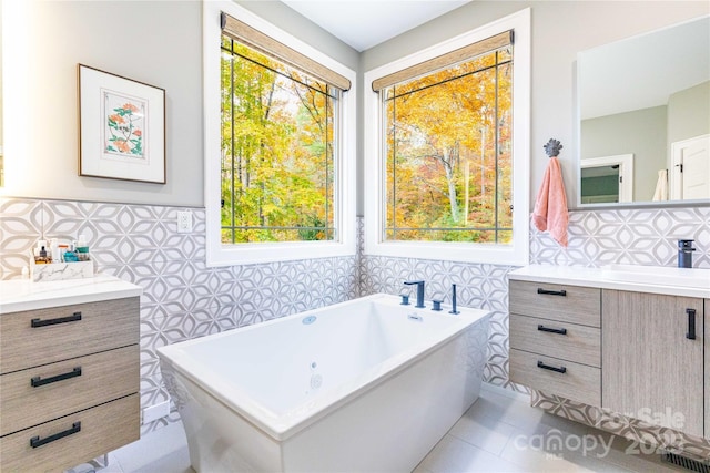 39 Hawks Pointe Ln, Weaverville, NC 28787 - full bathroom featuring vanity, tile walls, a jetted tub, wainscoting, and tile patterned floors