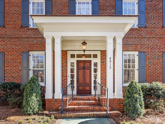 view of exterior entry featuring brick siding