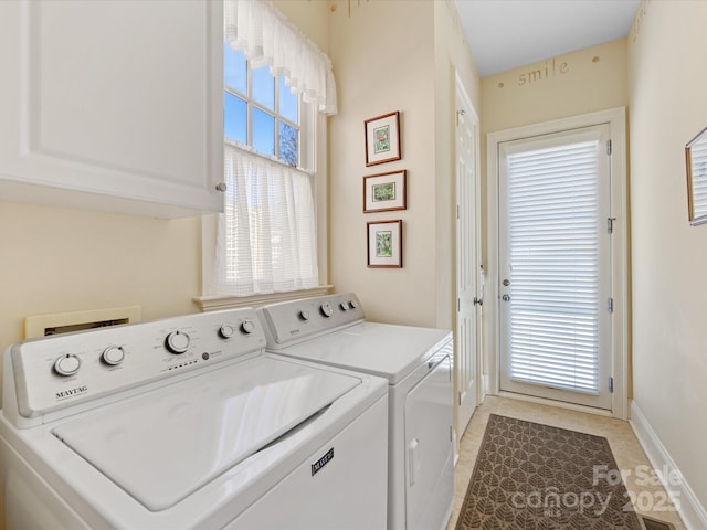 washroom with cabinet space, baseboards, and washer and dryer