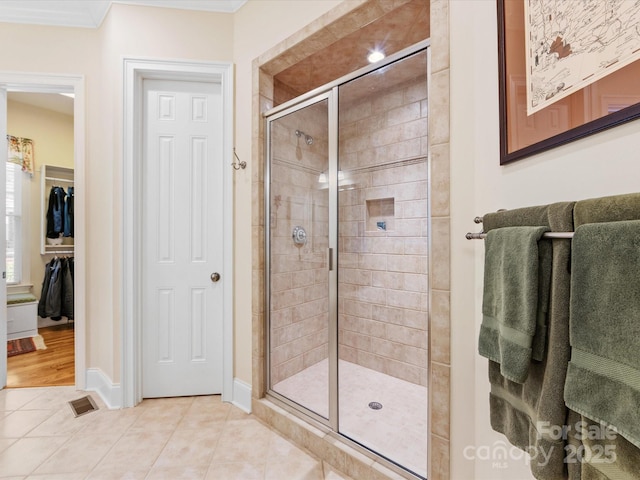 bathroom with a stall shower, visible vents, baseboards, and tile patterned floors