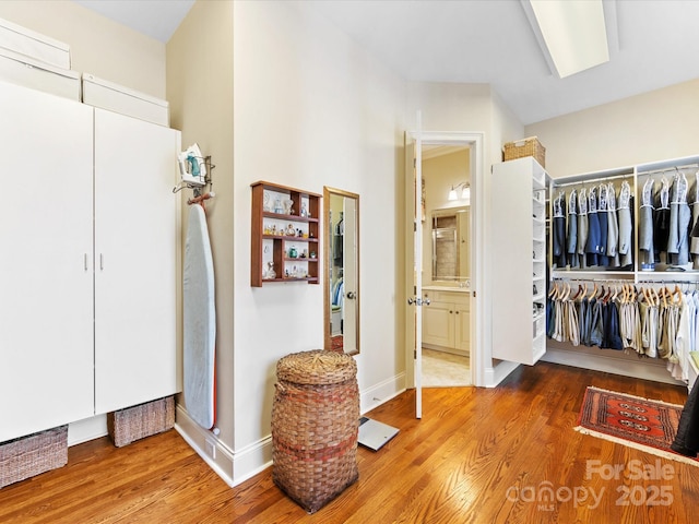 walk in closet with wood finished floors