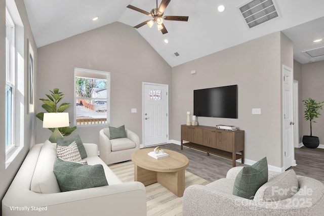 living room with light wood-style flooring, visible vents, and a ceiling fan