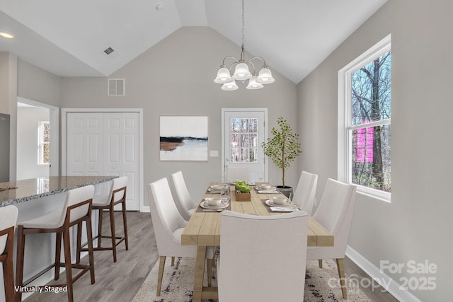 dining area with light wood-type flooring, a healthy amount of sunlight, and visible vents