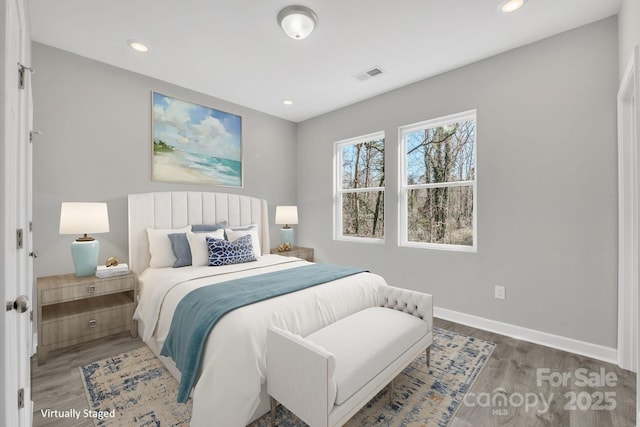 bedroom with recessed lighting, wood finished floors, visible vents, and baseboards